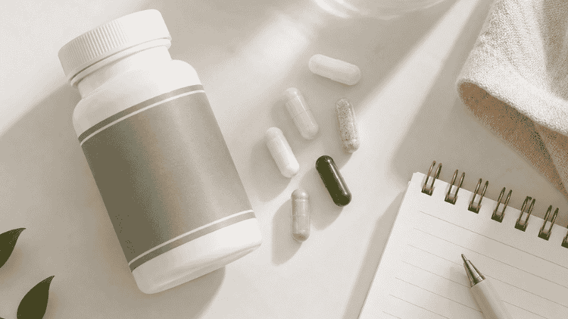 Magnesium supplement bottle next to various medications representing drug interaction timing and spacing considerations