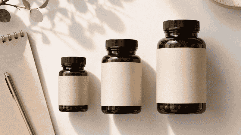 Three supplement bottles of different sizes representing vitamin D dosage levels from maintenance to deficiency correction
