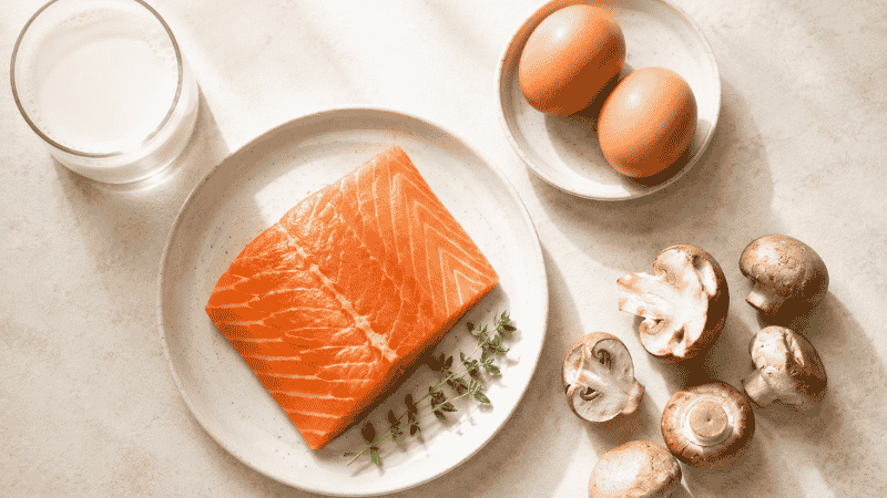 Flat lay of vitamin D rich foods including salmon eggs mushrooms and milk representing natural dietary sources of vitamin D